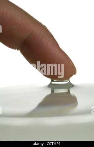 Finger, die Oberflächenspannung des Wassers zu demonstrieren Stockfoto