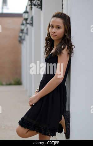 Ein elf Jahre altes Mädchen Mischlinge (asiatische/Kaukasier) stützt sich auf eine Säule Stockfoto