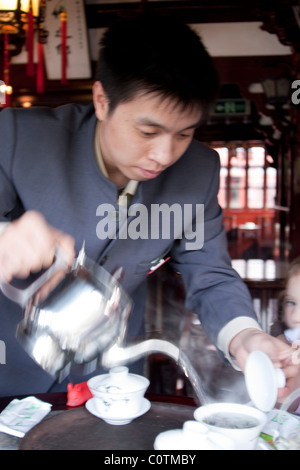 Chinesischer Mann Gießen Tee in Tee Haus Yu Yuan Shangcheng, Yu Gärten Bazaar, Shanghai, China Stockfoto