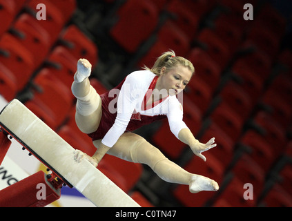 Weiblicher Gymnast führt einen Handstand mit nur einem Arm am Balken bei einem Gymnastik-Wettbewerb Stockfoto