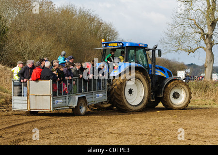 Viele Leute in einem Anhänger von einem Traktor gezogen werden Stockfoto