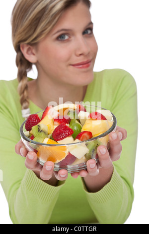 Gesunde Lebensweise Serie - Frau mit Obstsalat auf weißem Hintergrund, Fokus auf Schale Stockfoto