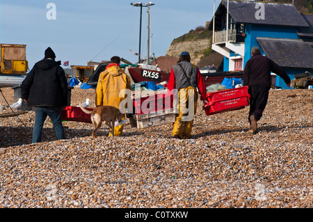 Fischer gehen mit ihren Fang auf dem Stade Strand Hastings East Sussex England Stockfoto