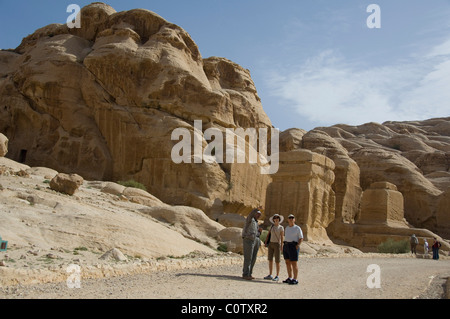 Jordan, antiken nabatäische Stadt Petra entfernt. Touristen mit Guide vor Ruinen der Dschinn Blöcke. Stockfoto