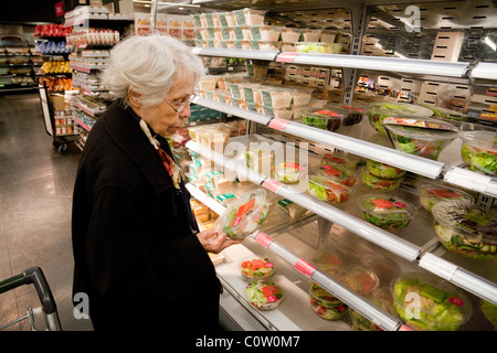 Eine ältere Dame shopping für Lebensmittel, Markierungen und Spencer, M & S Bromley, Kent UK Stockfoto