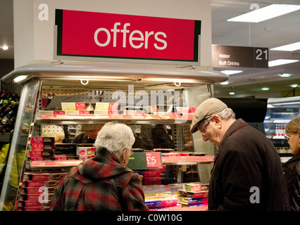 Ein altes, älteres Paar, das in der „Angebote“-Abteilung der Marks and Spencer Foodhall, Kent, Großbritannien, Lebensmittel einkauft Stockfoto