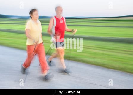 Ältere Frau und Mann zu Fuß, Nordic-walking, Bewegungsunschärfe, Waldviertler Region, Niederösterreich, Österreich Stockfoto