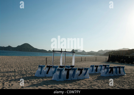 Stühlen und einem Bogen Hochzeit richten Sie an einem Strand warten auf Gäste und die Braut und der Bräutigam ankommen. Stockfoto