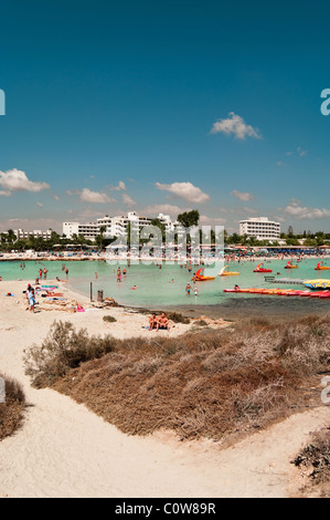 Greifen Sie auf Mittelmeer, Nissi Beach, Ayia Napa, Zypern.  Menschen am Strand und im Wasser, Hotels auf Hintergrund Stockfoto