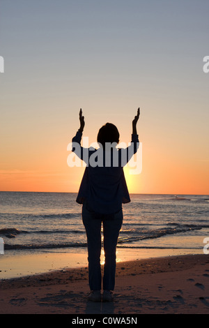 Frau wirft ihre Hände zum Himmel in Lobpreis und Anbetung. Raum für Kopie an Spitze. Stockfoto