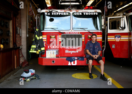 Feuerwehrmann sitzt vor einem Feuerwehrauto in New York Stockfoto