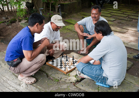 Männer spielen ein Schachspiel am Straßenrand in Sanur, Bali, Indonesien Stockfoto