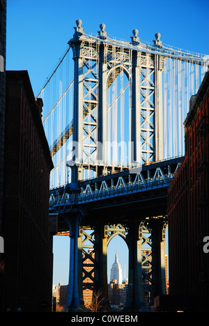 Das Empire State Building ist unter dem Bogen der Manhattan Bridge umrahmt. Stockfoto