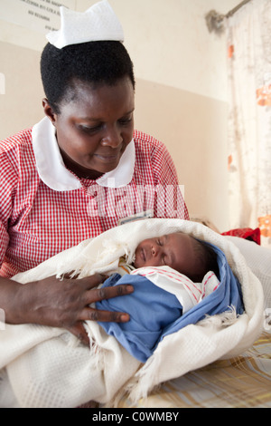 Eine Krankenschwester hat ein neugeborenes Baby in einer Klinik in Jinja District, Uganda, Ostafrika. Stockfoto