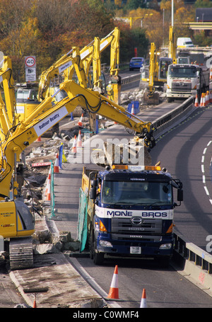 Bagger bei Straßenbauarbeiten auf der M621 Autobahn füllen LKWs mit Schutt, Leeds Yorkshire UK Stockfoto