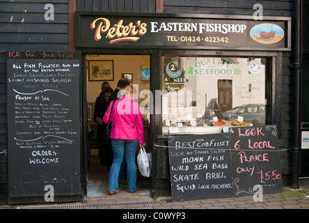 Kunden, die Schlange In ein Fischhändler Hastings East Sussex England Stockfoto