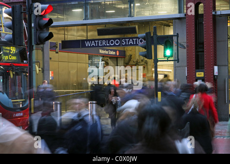 Menschen beim Überqueren der Straße und zu Fuß in Waterloo Bahnhof in den Feierabendverkehr, einen Bus und Ampel auf der linken Seite Stockfoto