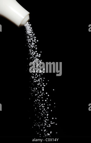 Strömenden Salzkörner auf schwarzem Hintergrund Stockfoto