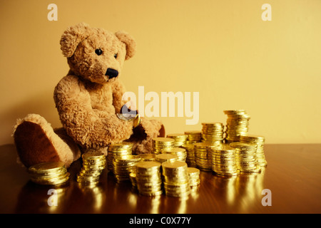 Ted steckt in seiner Schokolade Goldmünze Investition. Stockfoto