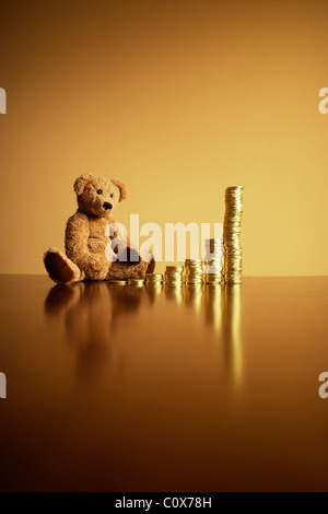 Anlagerenditen: exponentielles Wachstum. Ted sieht zukünftiges Wachstum mit seinem Haufen Schokolade Goldmünzen. Stockfoto