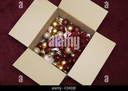 Die öffnende Schachtel mit Weihnachtsdekorationen Kugeln und Lametta aus früheren Jahren ist bereit, einen Weihnachtsbaum zu dekorieren Stockfoto