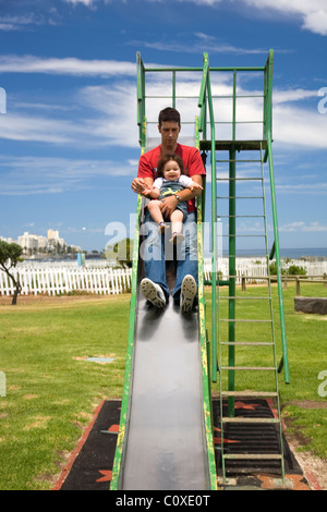 Vater und Tochter hinunter Folie am Spielplatz Stockfoto
