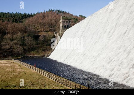 Fließende, Stein Wasserturm, Bäume am Hang Howden Damm am oberen Derwent Valley Reservoir im Peak District, Derbyshire Stockfoto