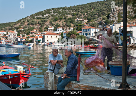 Ein Fischer im Chat und ausbessern Netze im Hafen von Agia Kyriaki auf der Halbinsel Pilion Griechenland Stockfoto