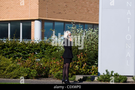 Business-Frau telefonieren mit Handy außerhalb ihres Büros Stockfoto