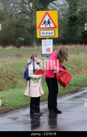 Schülerinnen und Schüler zu Fuß von der Schule entlang einem Feldweg mit keinen Bürgersteig Hampshire England UK Stockfoto