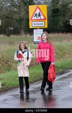 Schülerinnen und Schüler zu Fuß von der Schule entlang einem Feldweg mit keinen Bürgersteig Hampshire England UK Stockfoto