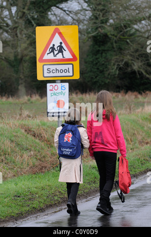 Schülerinnen und Schüler zu Fuß zur Schule entlang einem Feldweg mit keinen Bürgersteig Hampshire England UK Stockfoto