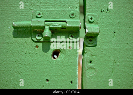 Alte Schleuse auf der grünen Holztür. Stockfoto