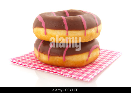 Rosa gestreifte Donuts mit Chocolat auf Papierserviette isoliert auf weiß Stockfoto