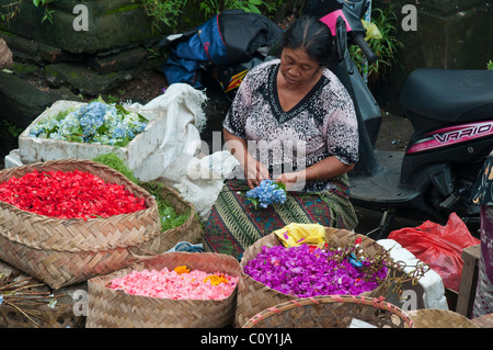 Frau verkaufen Blütenblätter für die Herstellung von Angeboten auf dem Markt in Ubud Bali Indonesien Stockfoto