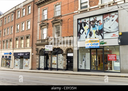 Nottingham Geschäfte geschlossen im März 2011 während der Wirtschaftskrise zu lassen. Beschilderung für weißes Material Bekleidung. Zeitungen unter Windows Stockfoto