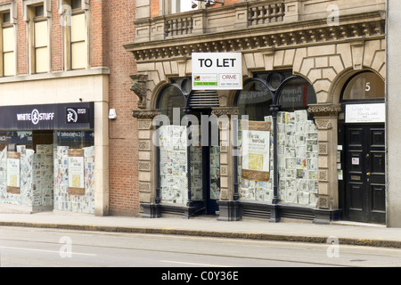 Nottingham Geschäfte geschlossen, um im März 2011 in Zeiten der Wirtschaftskrise zu lassen. Beschilderung für weiße Sachen Kleidung. Zeitungen auf windows Stockfoto