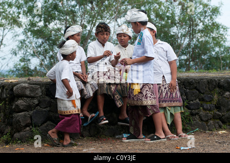 Junge balinesische Jungen, die sich für ein religiöses fest verkleidet haben, spielen gemeinsam auf einem Tempelfest in Padang Bai im Osten von Bali Indonesien Stockfoto