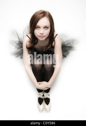 Porträt von teenage Tänzer sitzt auf einem weißen Hintergrund tragen eine schwarze Tutu. Stockfoto