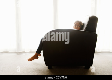 Sechs Jahre sitzt altes Mädchen im Art Deco Stil Sessel neben Fenster. Stockfoto