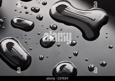 Wassertropfen mit Regenschirm Form auf schwarzem Hintergrund. Stockfoto