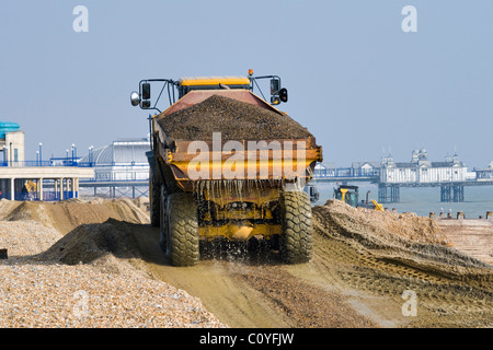 Ein artikuliert LKW Transport von Kies während in Strand Restaurierungsarbeiten in Eastbourne an der Südküste des Vereinigten Königreichs Stockfoto