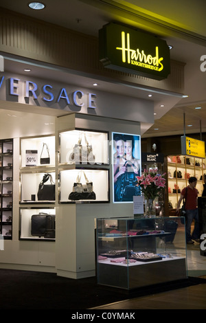 Versace-Bags für Verkauf im Harrods-Shop / Filiale in der Abfahrt lounge am Flughafen London Heathrow Terminal 3. Stockfoto