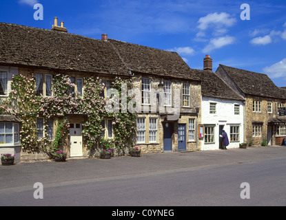 Historische Lacock High Street alte Ferienhaus wohnungen Kletterrose Strauch Blumen & National Trust shop Tür öffnen in Wiltshire England Großbritannien Stockfoto