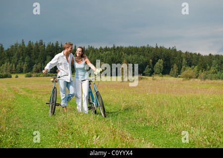 Romantische junges Paar mit alten Motorrad im Frühjahr Natur an sonnigen Tag Stockfoto