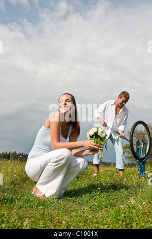 Romantische junges Paar mit alten Motorrad im Frühjahr Natur an sonnigen Tag Stockfoto