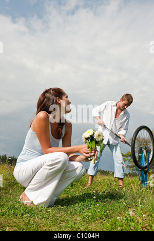 Romantische junges Paar mit alten Motorrad im Frühjahr Natur an sonnigen Tag Stockfoto