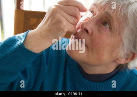 Ältere Frau ins anti-Histamin-Augentropfen zur Linderung der Symptome von Heuschnupfen hautnah Stockfoto