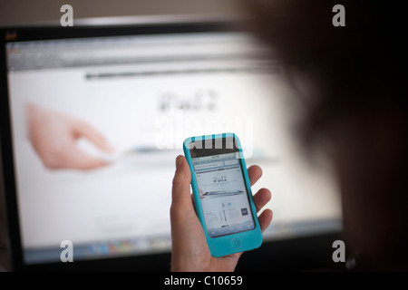 Eine Shopper durchsucht die Apple-Store-Website mit dem neuen iPad 2, auf ihrem iPod in New York Stockfoto