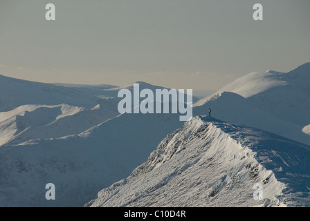 Einsamer Wanderer auf dem Gipfelgrat des Schnees überdacht im Winter im englischen Lake District Blencathra Stockfoto